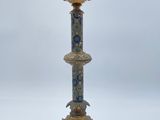 un bougeoir ancien en laiton orné d'un motif bleu et blanc