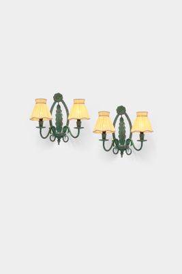 a pair of green sconces mounted on a wall next to a lamp