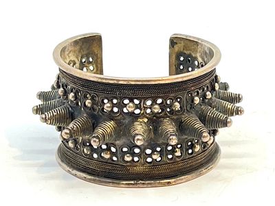 bracelet manchette en argent orné de pointes et de rivets sur fond blanc