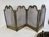 pair of antique brass fireplace screen with a hat on top of it