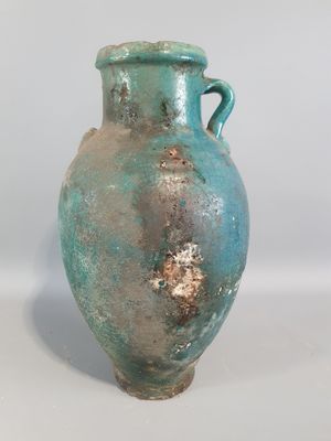 un vase bleu posé sur une surface blanche