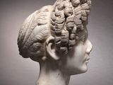 marble bust of a woman with curly hair on a marble base