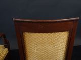 a wooden chair with a yellow upholstered seat next to a chair with a yellow upholstered seat
