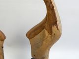 deux sculptures en bois représentant un oiseau, posées sur un socle noir