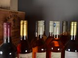 several bottles of wine are lined up on a shelf next to a wooden box