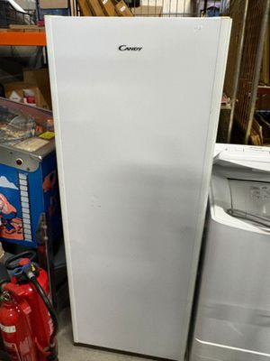 a white refrigerator sitting in a garage next to a fire hydrant