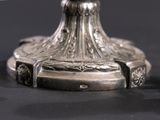 a close up of a silver candle holder on a table