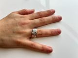 a person ' s hand with a silver ring on it