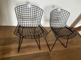 two black wire chairs sitting on top of a wooden floor