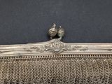 a silver metal purse with a bird on top of it