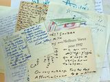 Des papiers et des notes manuscrites sont empilés les uns sur les autres sur une table