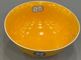 yellow and white bowl sitting on top of a gray table