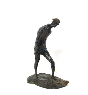 une statue représentant un homme tenant une batte de baseball au sommet d'un rocher