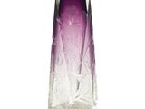 un vase violet posé sur une surface blanche