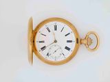 a gold pocket watch with roman numerals on it