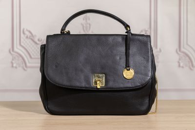 a black handbag sitting on top of a wooden table
