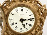 a gold clock with roman numerals on the face