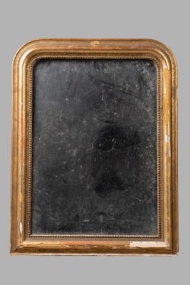 an old gold framed mirror with a black background on a gray wall
