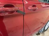 a red car with a remote control on the door handle