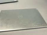 a dell laptop sitting on a table next to a keyboard