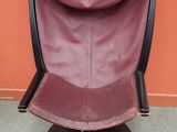 fauteuil en cuir violet devant un mur orange, avec un piètement noir