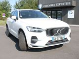 the front of a white volvo suv parked in front of a building