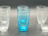 three glasses sitting on a table with water in them