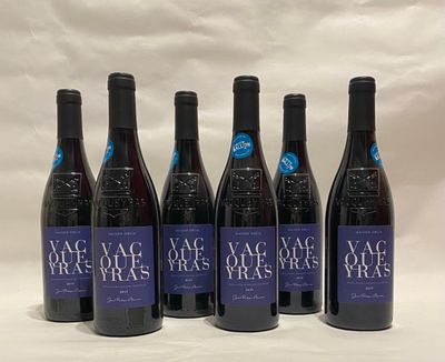 six bottles of wine are lined up on a white surface