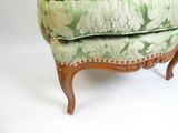 un fauteuil rembourré à motifs floraux verts et blancs sur fond blanc