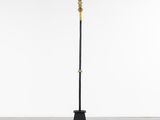 a black and gold floor lamp with a cross on it