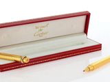 une boîte rouge contenant un stylo et un stylo doré