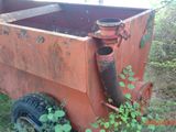 a rusted out dumpster sitting in the middle of a field