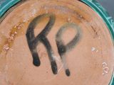 a close up of a green vase with graffiti on it