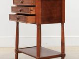an old wooden table with three drawers and a drawer underneath it