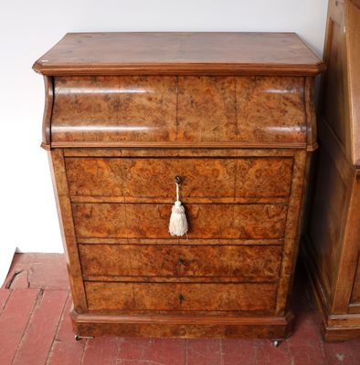 une petite commode en bois surmontée d'un pompon