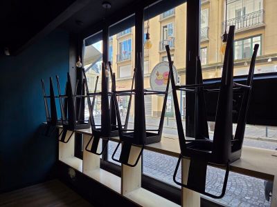many umbrellas hanging on the windowsill of a restaurant