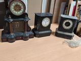 three clocks sitting on a table next to each other