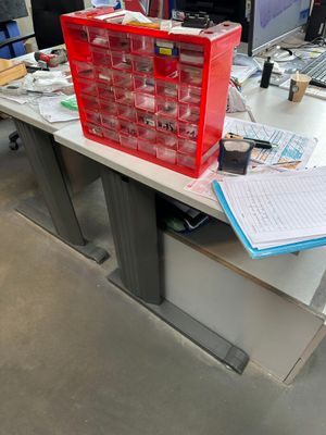 un bureau sur lequel se trouvent un ordinateur et une boîte rouge