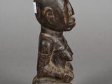 an old wooden figurine of a man holding a baby
