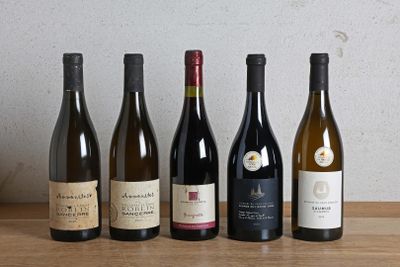 plusieurs bouteilles de vin sont alignées sur une table en bois