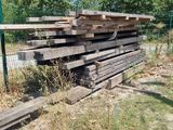 a pile of lumber sitting on the ground next to a fence