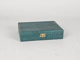 a small green box with a gold clasp on it