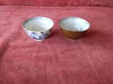 two bowls sitting on a red cloth on a table