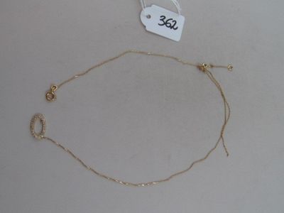 un collier avec une chaîne en or posé sur une table blanche
