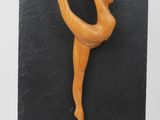 a close up of a figurine of a woman on a black slate board