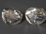 pair of silver heart shaped earrings with engraved names on them