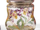 a glass jar with flowers painted on it next to a vase