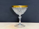 a wine glass with a gold rim on a table