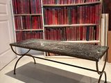 une table au plateau en marbre placée devant une bibliothèque