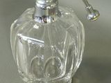 a clear glass bottle with a metal handle on a table